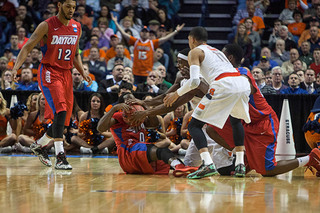 Syracuse and Dayton players hit the floor and battle for possession. 