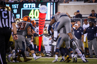 Three Syracuse defenders try and bring down a Notre Dame ball carrier.