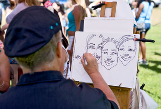 Artists drew caricatures of concertgoers on Sunday. Besides the music stages, University Union also brought in bouncy castles and a Direct TV station broadcasting the day's football games for students to watch.