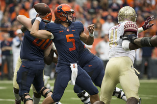 Syracuse quarterback Austin Wilson winds up to throw as Florida State closes in on the pocket. 