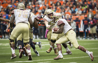 A Florida State running back moves toward a hole after receiving handoff. 
