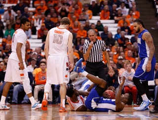 A Hampton player falls to the crowd after tangling up with an SU player and Cooney stares down at him. 