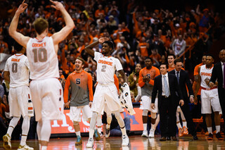 Syracuse sophomore forward B.J. Johnson salutes to the bench in the first half as Cooney raises his arms to pump up the crowd.