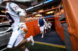 Syracuse players rush out of the locker room and onto the field to take on the Cornell Big Red. 