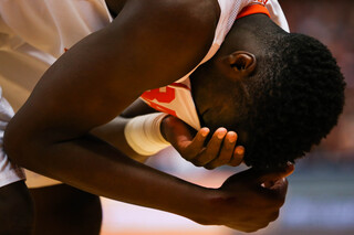 Tyler Roberson covers his face after getting cut during the first half. 