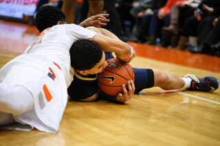 Gbinije wrestles for the ball after the two players tumble to the floor.