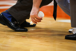 Trainers and coaches work to clean up the blood from the court following Roberson's injury. 