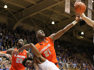 SU sophomore forward Tyler Roberson tries to corral a rebound while holding off Winslow.