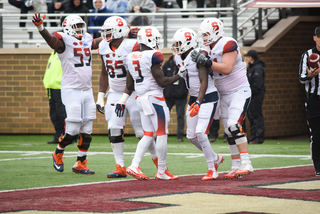 Syracuse players stand in the end zone crowding together.