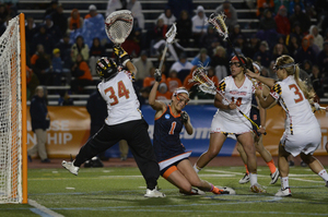 Alyssa Murray falls to ground trying to get a shot past Maryland goalie Kasey Howard. Murray kept SU in the game, but the Terrapins clamped down on her in the second half and advanced to the national championship.