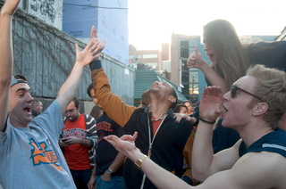 A large group of Syracuse University fans celebrate the orange's win out side of Chuck's Cafe.