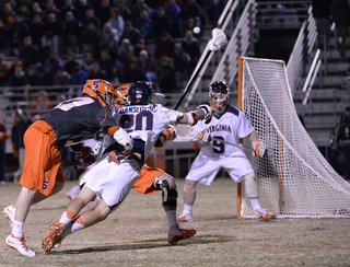 A crowd of players collide in front of the Virginia net. 