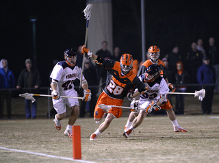 Syracuse long-stick midfielder Peter Macartney surges toward the attacking third above two Virginia defenders. 