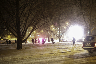 Women run across Walnut Park back to their new houses after opening their bids in Schine Student Center. 