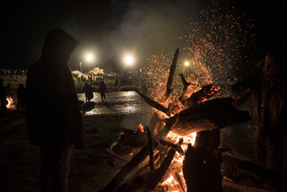 After attempting to extinguish one of the ceremonial fires near the barricade, water protectors set another fire further back as law enforcement watch from afar. The fires burned well into the morning of Nov. 21.