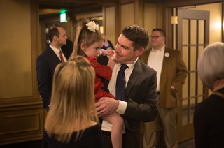 Walsh holds his daughter at the Hotel Syracuse, where his election watch party was held.