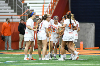 Syracuse huddles together after a goal.