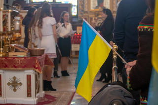 A Ukrainian singing group performs the Ukrainian national anthem while members of the congregation raise their flags high. 