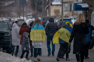 Members of the community wrap themselves in the Ukrainian flag in support. 